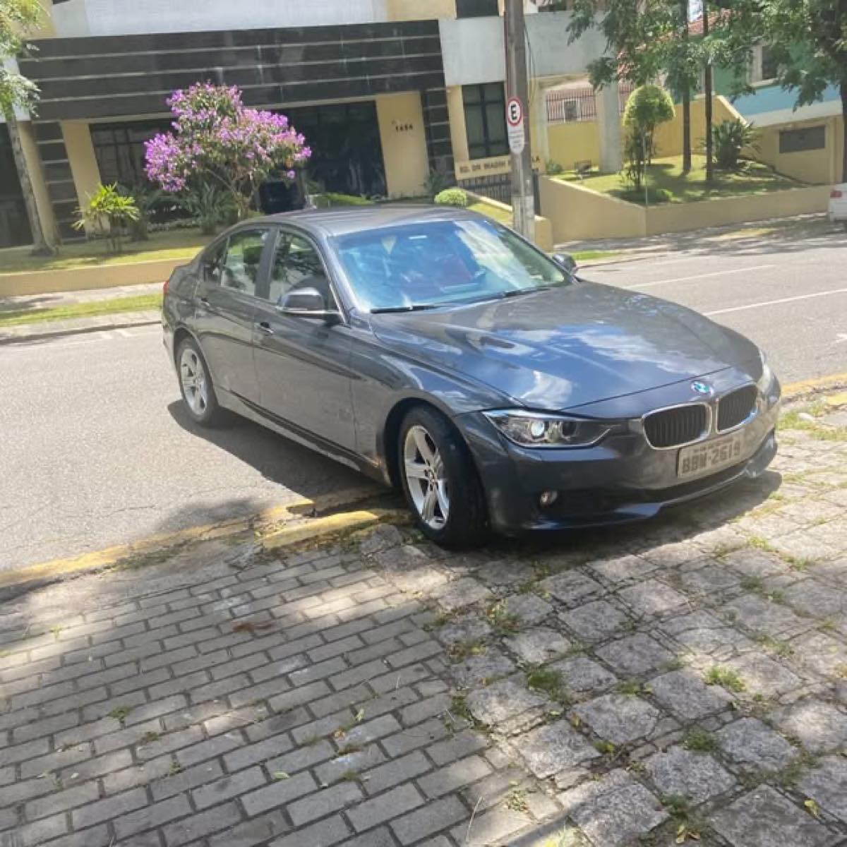 BMW cinza após serviço de estética automotiva, estacionado na rua